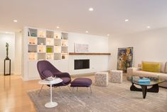 a living room filled with furniture and a fire place in the middle of it's wall