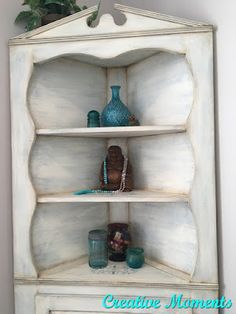 a white shelf with vases and other items on it