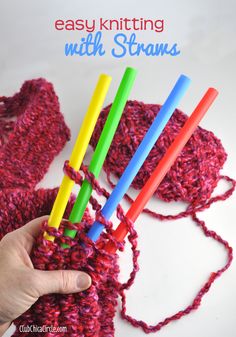 someone is knitting with crocheted yarn and holding four colorful straws in their hand