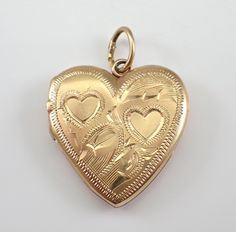 Vintage 14K Yellow Gold Heart Locket Charm Pendant. This charm is 14K Yellow gold and weighs 1.9 grams. This locket measures 18 X 18 mm.  I will ship this pendant promptly in a gift pouch. This adorable pendant will make a perfect gift for any occasion.  Give the gift of a vintage love representation with this adorable heart.  Mothers Day, Birthday, Anniversary, Graduation, or any special occasion. Collectible Gold Jewelry With Heart Charm, Heirloom Heart-shaped Jewelry With Hallmark, Collectible 14k Gold Heart-shaped Jewelry, Engraved Jewelry Collectible For Valentine's Day, Engraved 14k Gold Double Heart Jewelry, 14k Gold Engraved Double Heart Jewelry, Antique Yellow Gold Heart Cut Jewelry, Traditional Heart-shaped Yellow Gold Jewelry, Traditional Heart Charm Jewelry For Valentine's Day