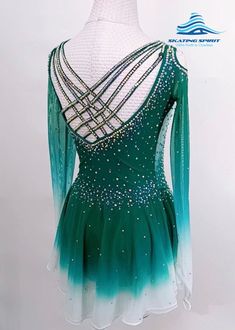 a green and white figure skating dress with beading on the neck, shoulders and arms