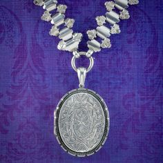 A magnificent antique Victorian collar from the late 19th Century bestowed with a large locket chased with elaborate patterning on both sides including a bouquet of forget me nots on the reverse, representing eternal love and remembrance.   The large collar articulates fluidly and has a wonderful, ornate design with further engraved artistry across the length. Both are fashioned in sterling silver and the locket is complete with rims and a window, ready to store two cherished family portraits so Victorian Oval Jewelry With Historical Design, Antique Silver Necklace With Historical Design, Traditional Medallion Jewelry With Historical Design, Antique Medallion Jewelry With Historical Design, Heirloom Necklace With Intricate Design For Ceremonial Use, Traditional Oval Jewelry With Historical Design, Ceremonial Medallion Jewelry With Historical Design, Victorian Oval Locket Necklace With Intricate Design, Victorian Engraved Necklaces For Ceremonial Occasions