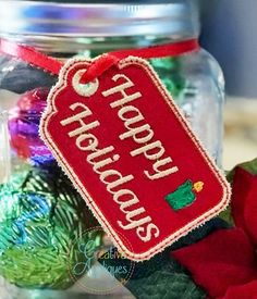 a christmas ornament hanging from the side of a glass jar filled with ornaments