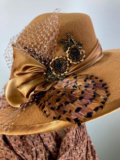 This butterscotch/camel/caramel widebrim hat is flat out fabulous! It is hand blocked over a vintage hat block and hand sewn with many tiny stitches. The crown (top) of the hat comes to a soft point and the brim has a slight down turn. Millinery wire is sewn inside of the brim edge to help the hat keep it's shape. The band and brim edge is a gorgeous hand dyed silk ribbon. It's finished with a three loop now, two pretty beaded sequin flowers, coordinating feathers and a large bow of vintage nett Elegant Handmade Fedora With Short Brim, Handmade Elegant Fedora With Curved Brim, Elegant Handmade Fedora With Curved Brim, Elegant Handmade Short Brim Fedora, Handmade Elegant Fedora For Kentucky Derby, Handmade Elegant Wide Brim Hat Bands, Elegant Handmade Felt Fedora Hat, Vintage Fedora Top Hat For Fall, Elegant Brown Fedora For Fall