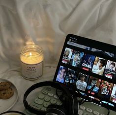 a laptop computer sitting on top of a table next to a plate of food and a candle