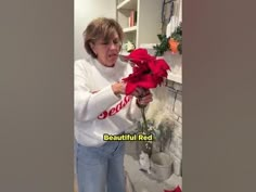 the woman is holding a red rose in her hand