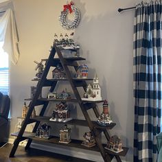 a christmas tree made out of wooden ladders in a living room next to a window