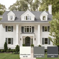 a large white house with black shutters and gray trim on the front door is shown