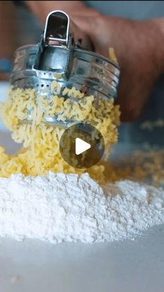 a person scooping yellow rice from a blender