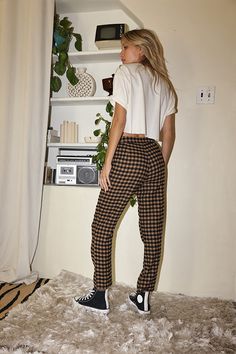 You are the trend setter in the Bishop Tan Checkered Cropped Trousers. Made with everyone's favorite checkered print and a straight leg fit, these are the pants you have been searching for! Style with a cropped tee or a chunky sweater, you will be able to rock these trousers in every way imaginable. STYLE RECOMMENDATIONS: - pair with some high tops and a cropped tee for a casual look, or spice it up with some wrap sandals and statement earrings SIZE RECOMMENDATIONS & MATERIALS: - light weight t Trendy Plaid Straight Pants, Gingham Cotton Pants For Fall, Trendy High-waisted Plaid Pants, Cotton Gingham Pants For Fall, Fall Gingham Cotton Pants, Fall High-waisted Houndstooth Pants, Casual Gingham Trousers, Plaid Long Pants For Fall, Fall Plaid Long Pants