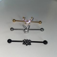 three different types of piercings on a white counter top, one with a deer head and the other with a flower