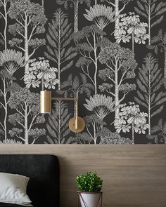 a black and white floral wallpaper in a bedroom with a potted plant next to it