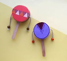 two ping pong paddles made out of paper and wood sticks with designs on them