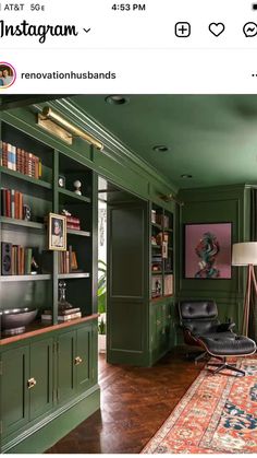 a living room with green walls and wooden flooring, bookshelves filled with books