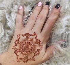 a woman's hand with a henna tattoo on it