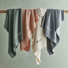 three towels hanging on a clothes line with the word dov written in white and pink