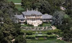 an aerial view of a large mansion surrounded by trees