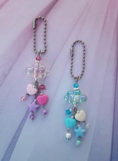 two key chains with charms attached to them sitting on a table next to each other