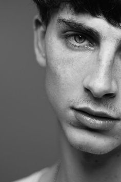 black and white photograph of a man with freckles on his face looking at the camera