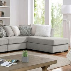 a living room with a sectional couch and coffee table in front of a large window