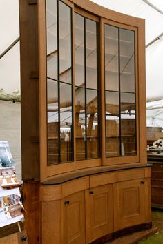 an old wooden china cabinet with glass doors on it's sides in a tent