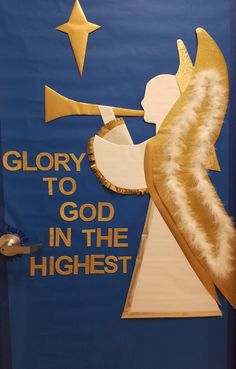 a door decorated with an angel holding a trumpet and the words glory to god in the highest