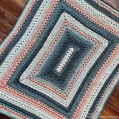 a crocheted blanket is laying on the floor