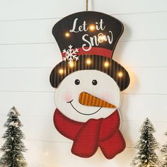 a lighted snowman hanging from the side of a wall