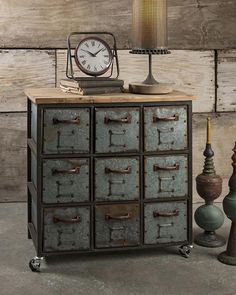 an old metal cabinet with many drawers and a clock on top, next to two lamps