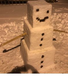 a snowman made out of two blocks in the snow, with one block missing