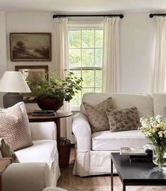 a living room filled with furniture and flowers in vases on top of a table