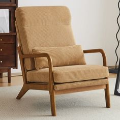 a brown chair sitting on top of a white rug next to a wooden dresser and lamp