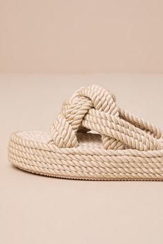 A cutie like you needs perfect summer sandals like the Dirty Laundry Knotty Natural Rope Flatform Slide Sandals! Twisted raffia rope, with a subtle sheen, shapes these summer-ready sandals with a rounded footbed, an open toe upper, and a wide vamp strap with intertwining knotted details. Simple slide-on design and a trendy flatform sole complete the look! 1. 5" wrapped flatform heel. Cushioned heel. Rubber sole has nonskid markings. Man made materials. Imported. Lulus | Knotty Natural Rope Flatf Beige Braided Sandals For Spring, Spring Beige Braided Sandals, Beige Braided Sandals For The Beach, Summer Braided Sandals With Adjustable Fit, Casual Beach Sandals With Rope Detail, Cream Sandals For Beach Season, Cream Sandals For Beach Vacation, Cream Sandals For Vacation And Beach Season, Beach Season Cream Sandals