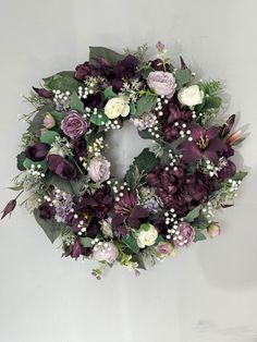 a wreath with purple flowers and greenery