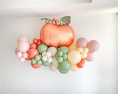 a bunch of balloons that are on the wall in front of a pumpkin and other decorations