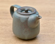 a teapot sitting on top of a wooden table