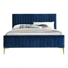 a bed with blue velvet upholstered headboard and pillows on top of it