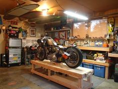 a motorcycle is on a work bench in a garage