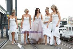 four beautiful women in white dresses standing on train tracks