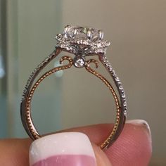 a woman's hand holding an engagement ring with two diamonds on the top and bottom