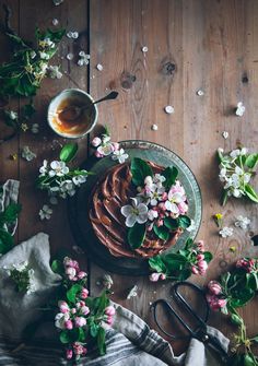 a table topped with flowers and cake next to a cup of tea on top of a plate