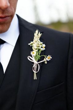 a man wearing a suit and tie with a boutonniere on his lapel