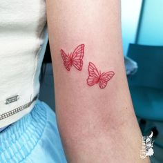 two red butterflies tattoo on the right arm and left arm, both with small wings