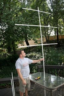 a man standing next to a table on top of a wooden deck in front of trees