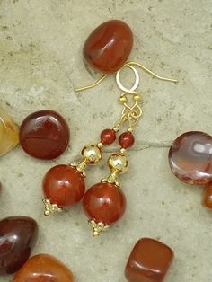 Enjoy creamy, richly colored genuine Carnelian gemstone beads accented with 14k and 18k real gold-plated pins, bead caps, and beads. Choose from three styles: (1) Two Carnelian beads with two gold plate bead caps and a gold plate bead in the middle. (2) Three Carnelian beads with one gold plate bead cap and gold-plated tiny beads. (3) Three Carnelian beads with two flat faceted gold plate beads. Your choice of hooks includes: (1) Gold-plated stainless steel French hooks (shown on Style 1). (2) Gold-plated stainless steel lever back hooks (shown on Style 2). (3) Gold plated copper lever back hooks (shown on Style 3). (4) Gold plated copper adjustable screw clip on hooks. These earrings measure about two inches (5 cm) from top to bottom. This varies a little with the style and hooks chosen. Gold Gemstone Bead Drop Earrings, Agate Drop Earrings Gift, Agate Drop Earrings For Gift, Agate Drop Earrings As A Gift, Gold Drop Earrings With Gemstone Beads, Hypoallergenic Agate Round Beads Jewelry, Elegant Carnelian Gemstone Bead Jewelry, Elegant Agate Gemstone Bead Earrings, Elegant Earrings With Gemstone Beads