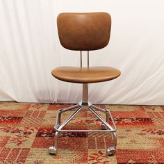 a brown chair sitting on top of a rug