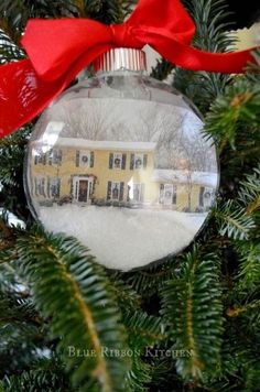 a christmas ornament hanging from a tree with a red bow on it's head