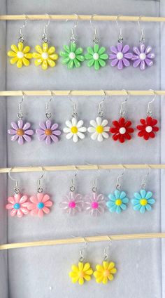 Add a splash of whimsy to your jewellery ensemble with our vibrant and adorable daisy flower earrings! Designed to inject a playful vibe into any collection, these earrings come in an array of colors, ensuring there's a pair to match every mood and outfit. Crafted with care, the earrings feature 0.925 silver-plated stainless steel hooks, providing both comfort and durability. Each earring is secured with a rubber back for ease of wear. The cute flower charms measure approximately 20mm by 16mm, p Cute Hypoallergenic Flower-shaped Jewelry, Summer 3d Flowers Earrings, Trendy Multicolor Flower Earrings, Playful Handmade Multicolor Flower Earrings, Playful Multicolor Handmade Flower Earrings, Summer Flower Charm Earrings, Summer Jewelry With 3d Flower Shapes, Summer Multicolor Earrings With Flower Charm, Whimsical Spring Flower Earrings With Ear Wire