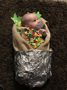 a baby wrapped in tin foil is laying on the floor