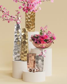 three vases with flowers in them are stacked on top of each other and one is gold